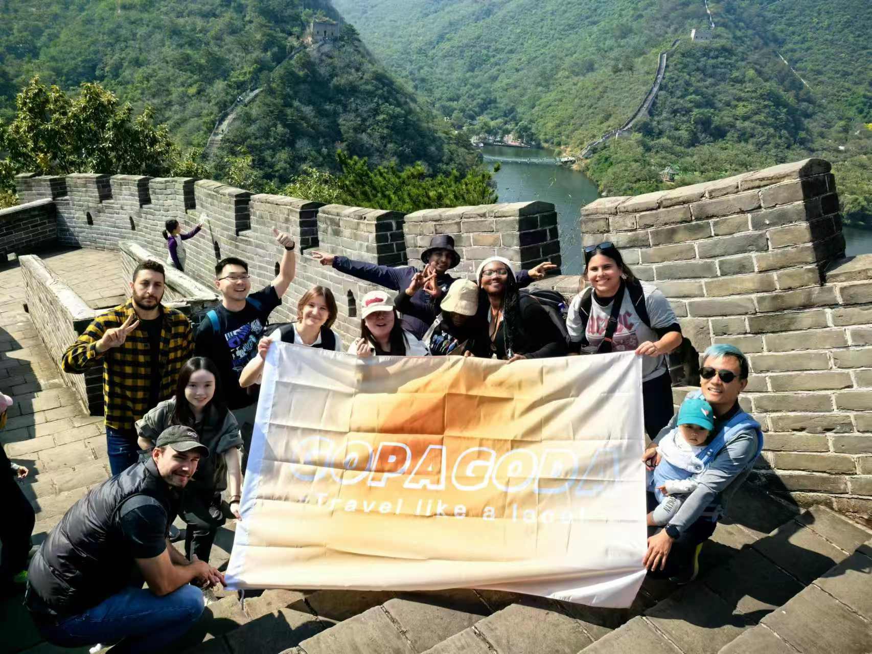 Travelers at the Great Wall of China with Gopagoda flag